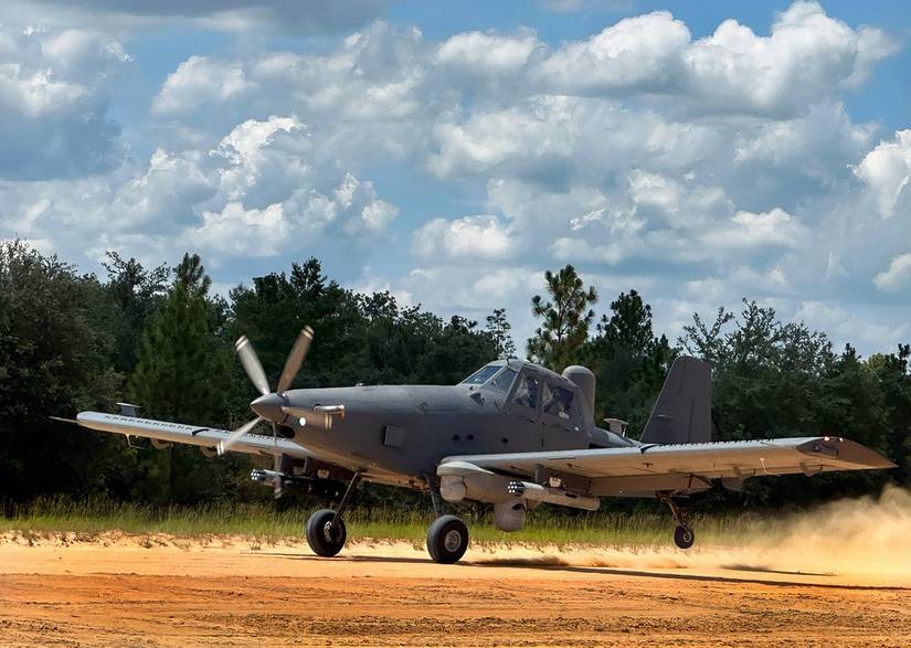 A Skyraider II making a landing on a dirt landing strip.
