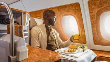 Male passenger having lunch service in Emirates Airbus A380 business class seat