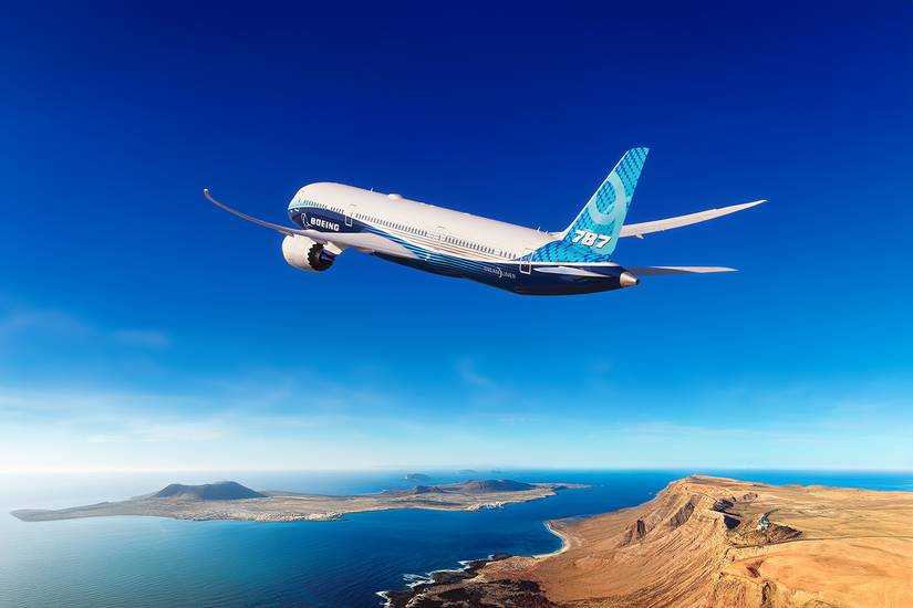 Boeing 787-9 Dreamliner flying over ocean and dessert