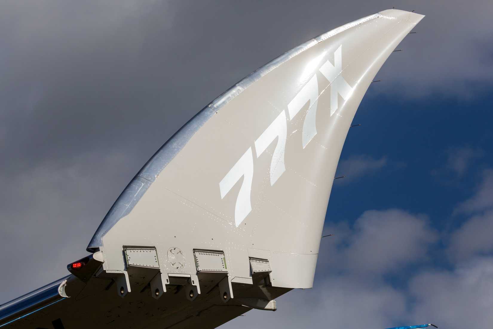 A Boeing 777X arrives at Boeing Field with wingtip folded after touchdown.