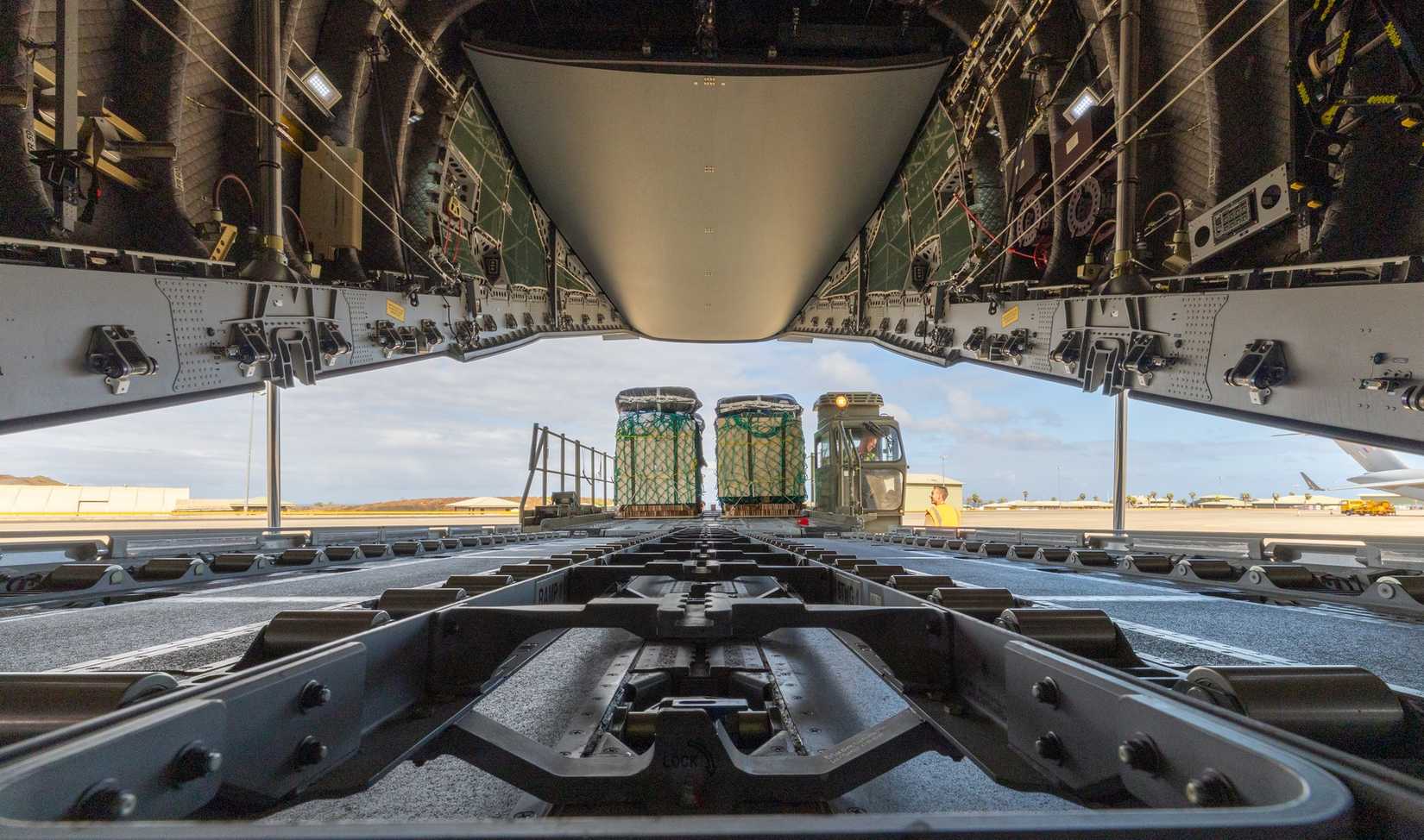A ground loader positioned at the cargo ramp of an RAF A400M after landing to support hantavirus aid ops.