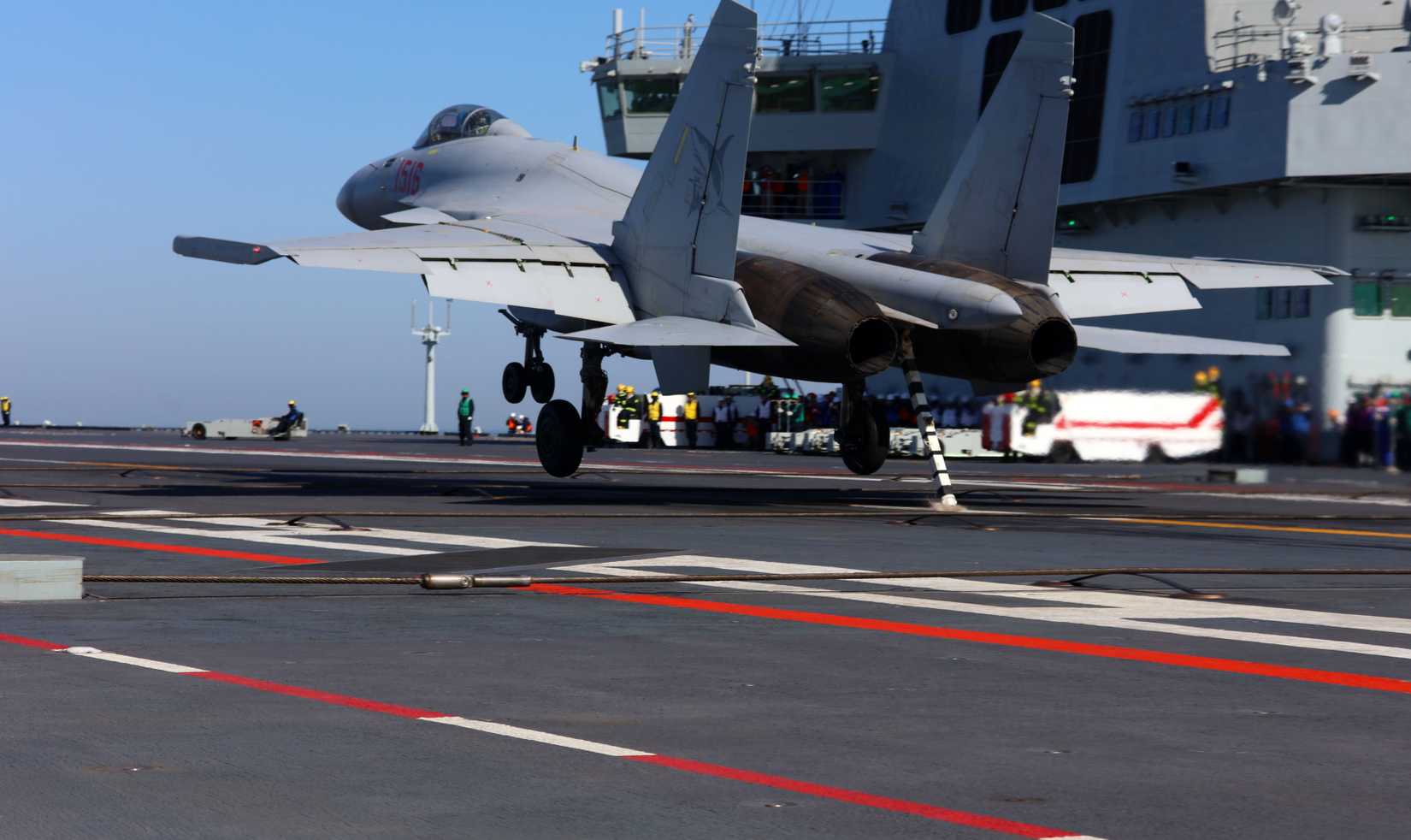 A J-15T heavy fighter jet lands on China's first electromagnetic catapult-equipped aircraft carrier, the Fujian (Hull 18).