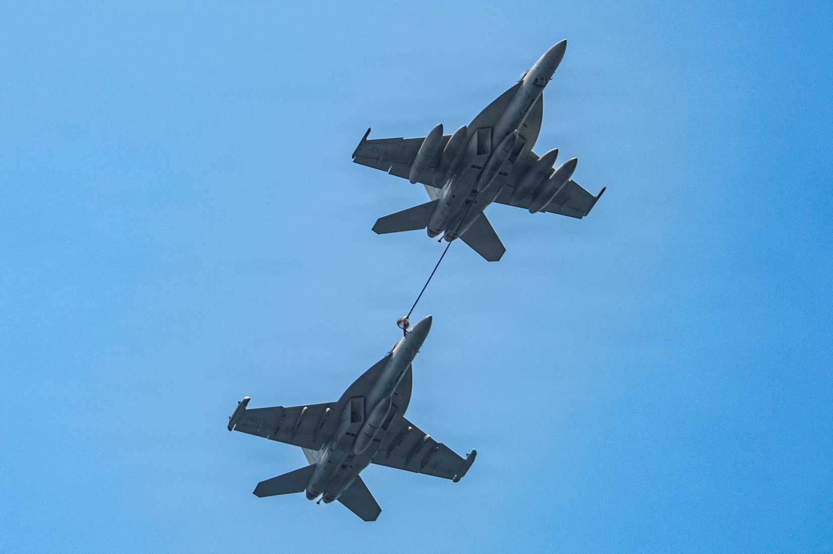 A Super Hornet and a Growler conduct an aerial refueling above the flight deck of Nimitz-class aircraft carrier USS Nimitz (CVN 68) in the Pacific Ocean, April 7, 2026.