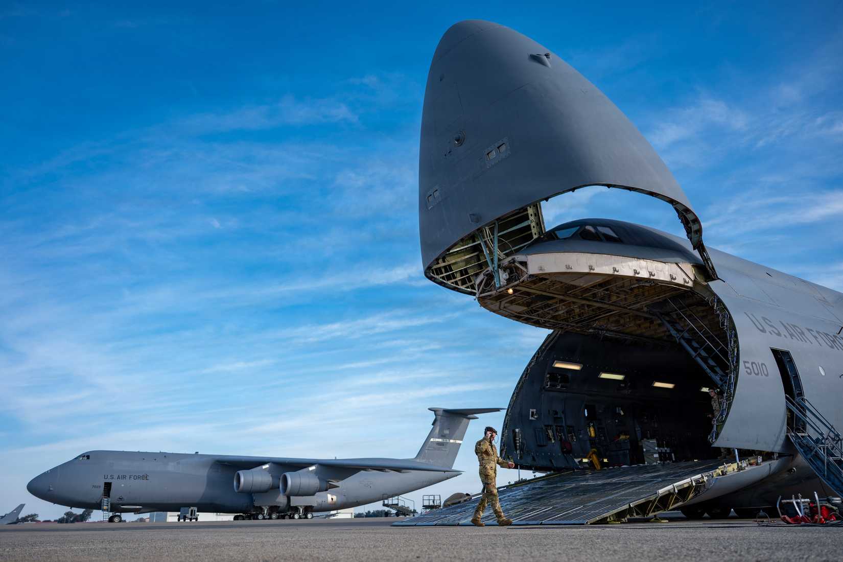 Air Force Airman 1st Class Alexander Smith, 22nd Airlift Squadron C-5M Super Galaxy flight engineer, assists in loading equipment on a C-5M.