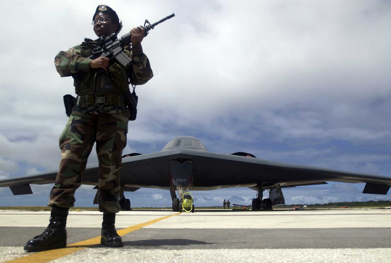 Air Force Airman Keundra McFadden guards a B-2 Spirit bomber on the flight line.