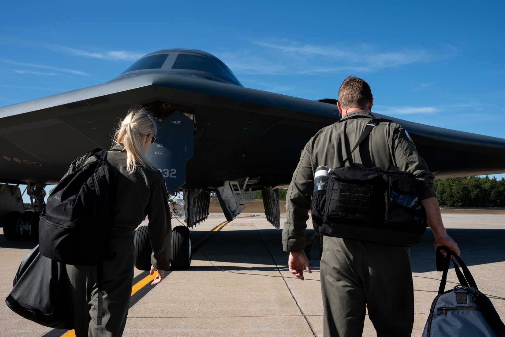 Air Force pilots assigned to the 393rd Bomb Squadron approach a B-2 Spirit aircraft.