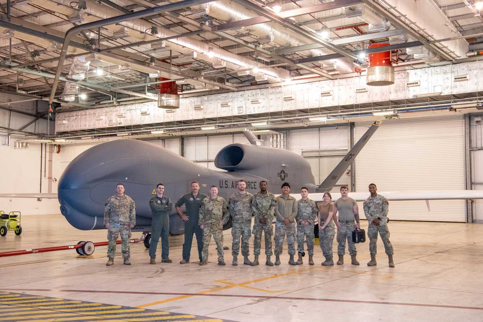 Airmen pose for a group photo in front of an RQ-4B Global Hawk assigned to Grand Forks Air Force Base’s 319th Reconnaissance Wing at RAF Fairford, England, Aug. 24, 2024.