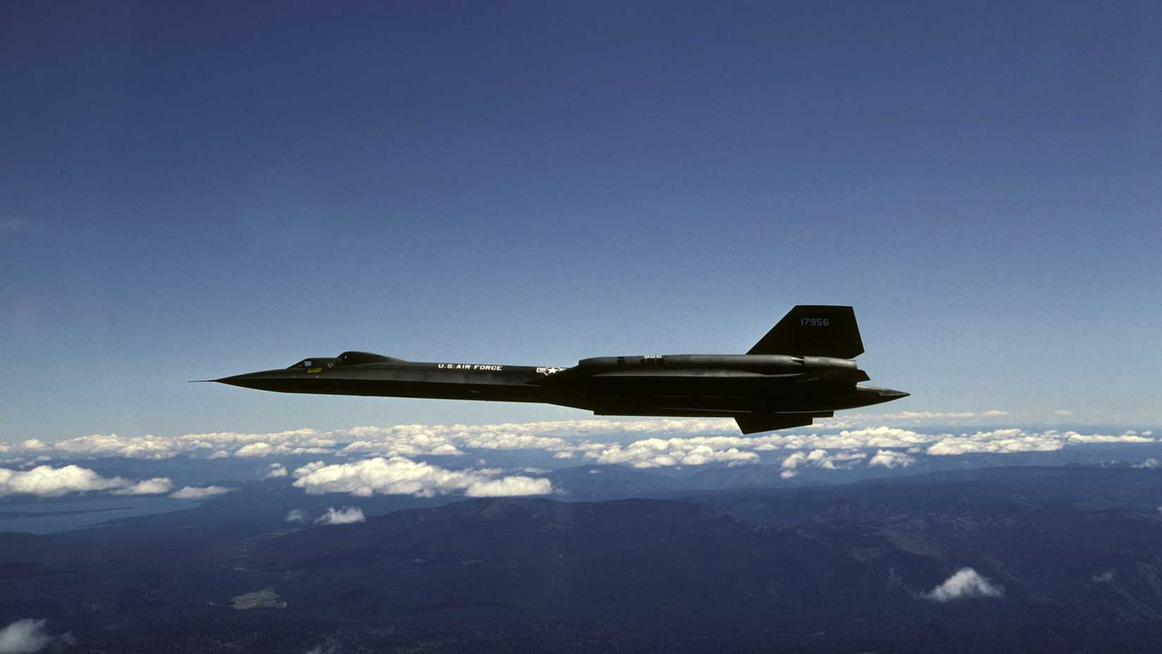 An air-to-air left side view of an SR-71B aircraft.