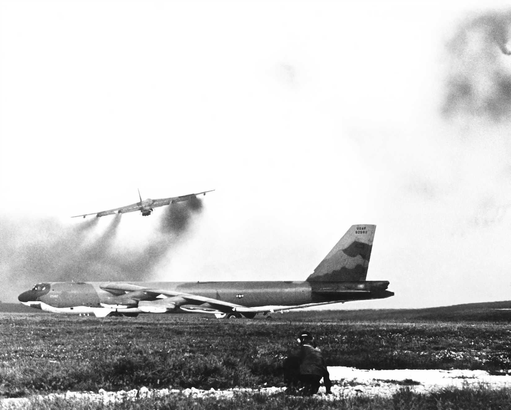 A B-52D takes off, while another waits for its turn. 