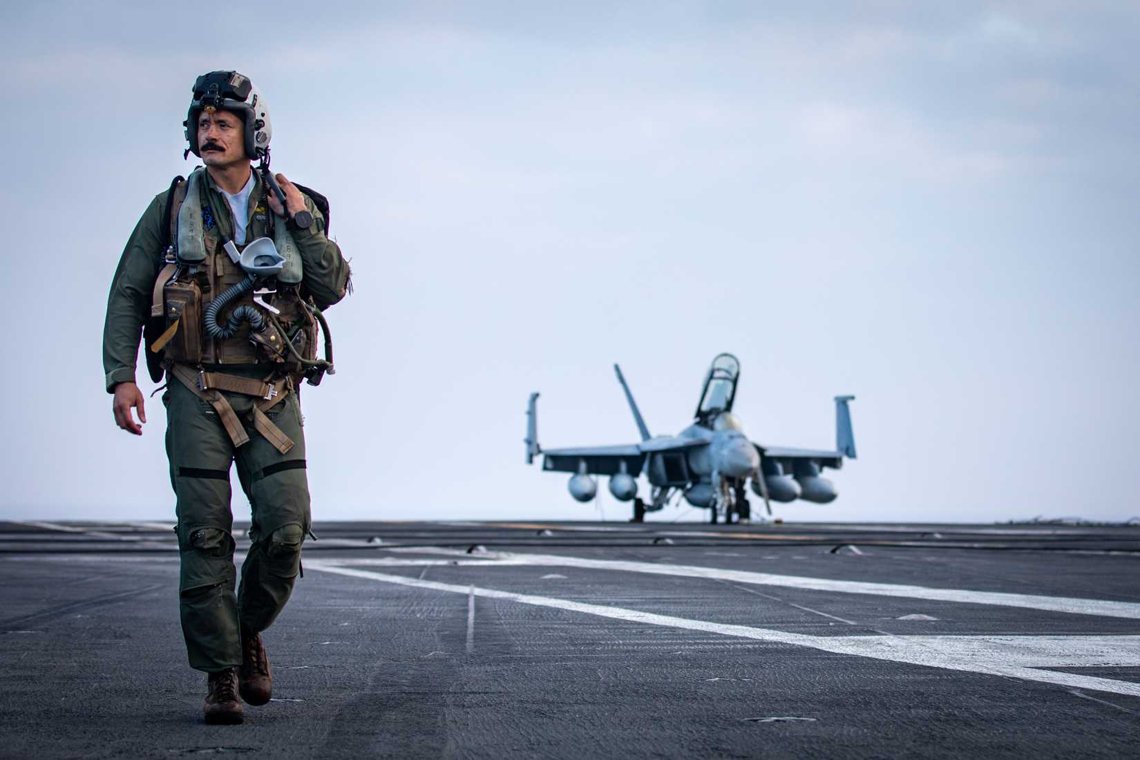 Lt. Cmdr. Komokana Fernandez, assigned to Strike Fighter Squadron 37, walks toward a Carrier Air Wing 8 FA-18E Super Hornet on the flight deck.