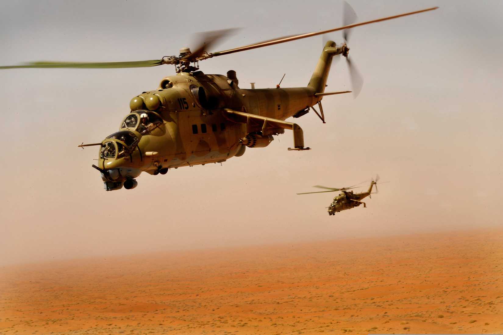 An Mi-35 flying above a desert or barren area. The Mi-35 is an export version of the Mi-24.
