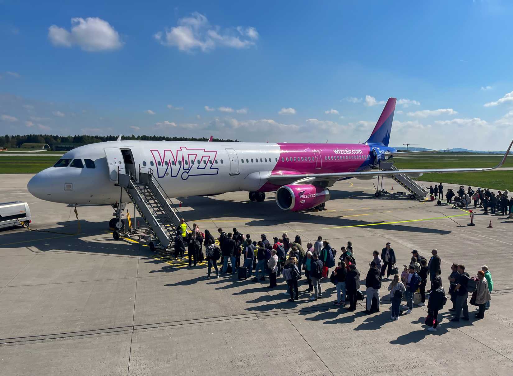 Passengers waiting on the tarmac for Wizz Air jet.-1