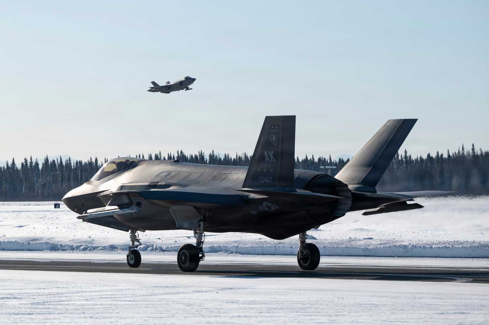 Air Force F-35A Lightning II taxis on the flight line as another takes off during ARCTIC EDGE 2026.