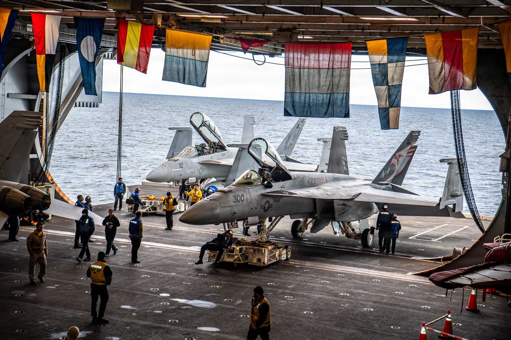 Sailors taxi two FA-18E Super Hornets onto an aircraft elevator onboard USS Nimitz in the Atlantic Ocean, April 27, 2026.