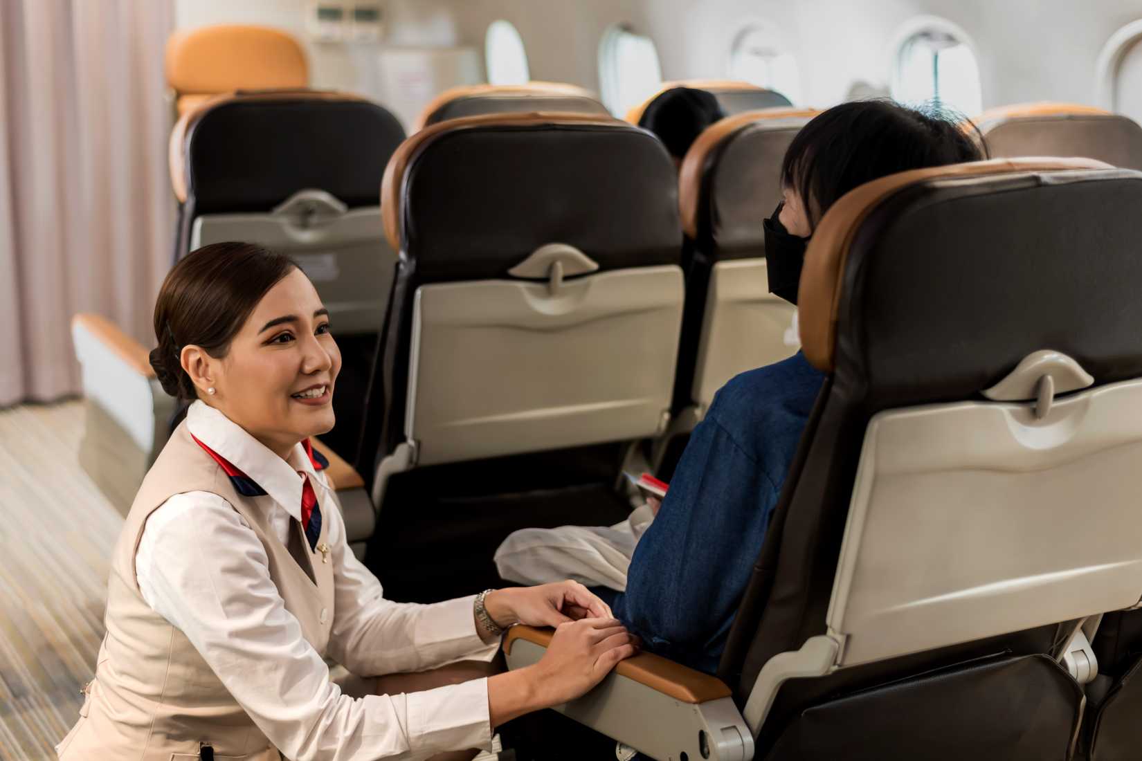 flight attendant speaking to passenger