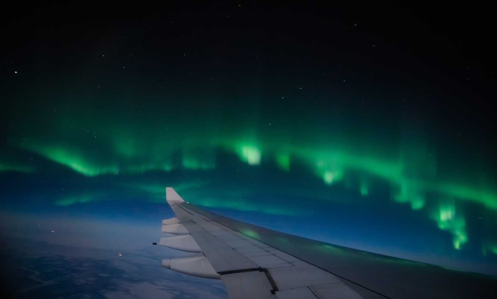 Aerial view of Northern Lights (Aurora Borealis) from an airplane flying over Northern hemisphere