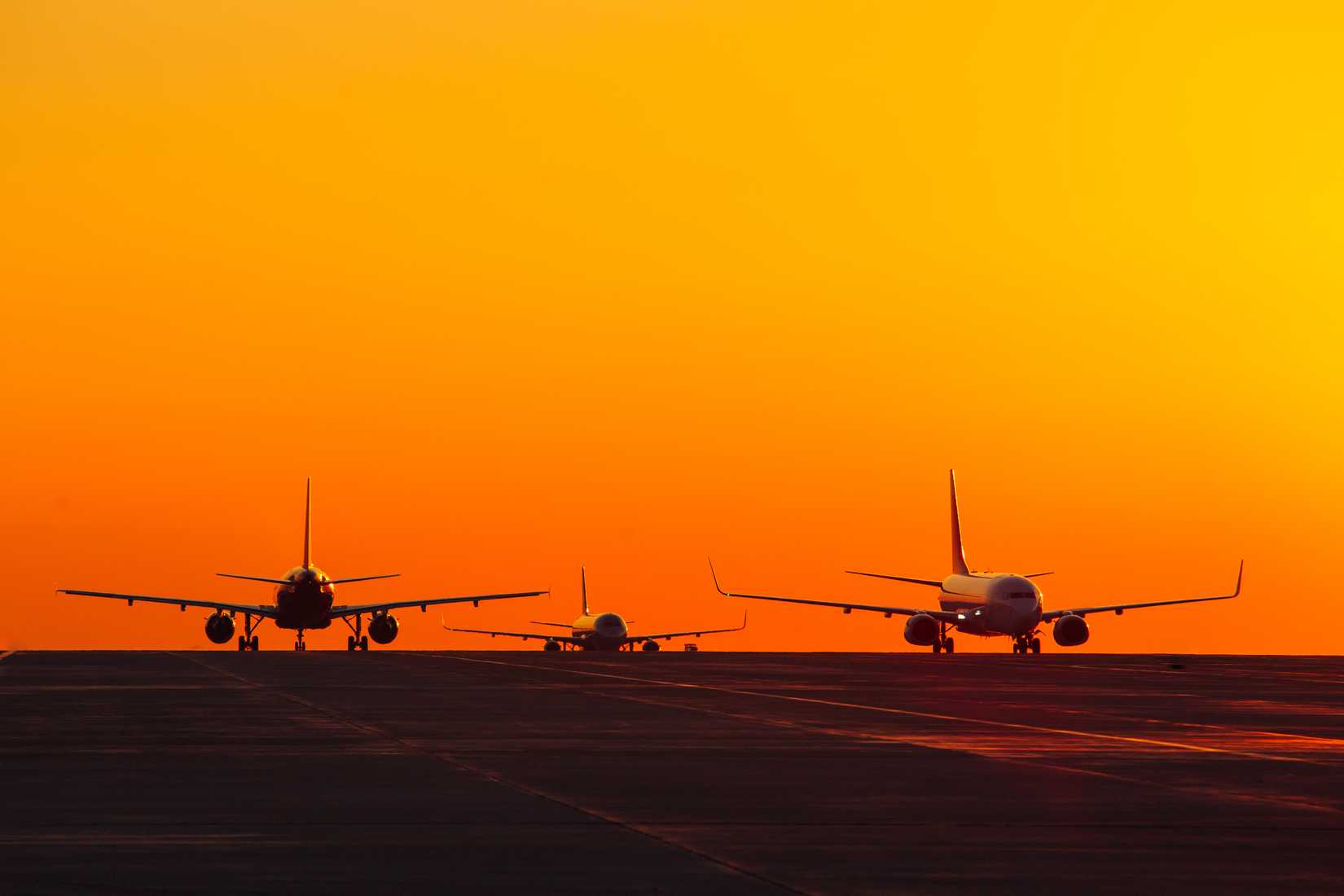 Silhouette of multiple aircraft taxiing on ground