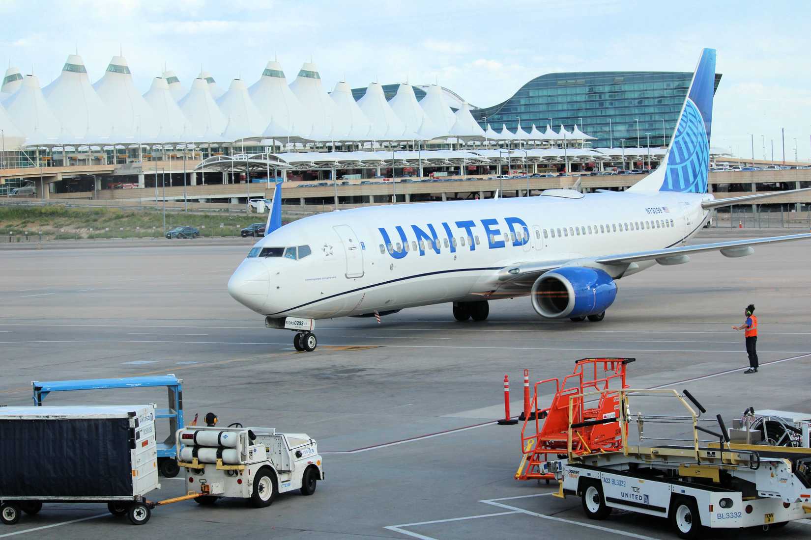 United Airlines 737 arriving at a gate with the main terminal and Westin Hotel beyond taken in the Denver, CO