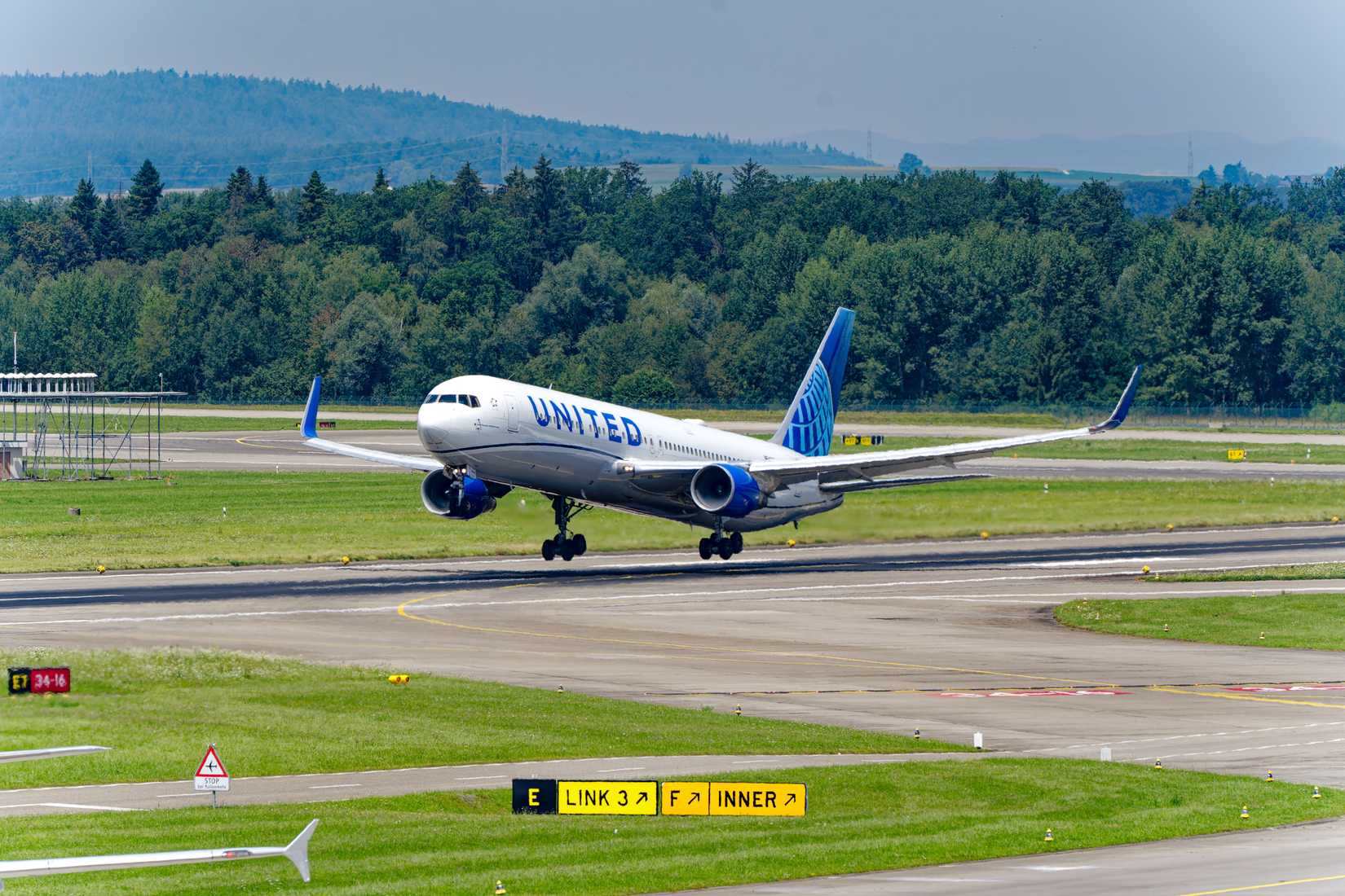 United Airlines Boeing 767-300 aircraft N675UA took off into the Swiss sky at noon on a sunny summer day.