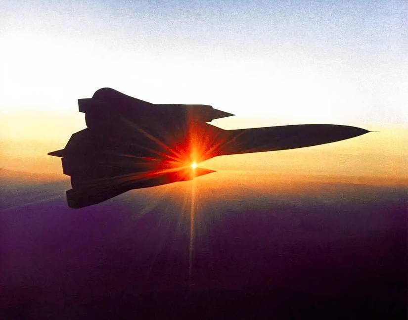 The silhouette of a YF-12 flying against the backdrop of a sunset. 