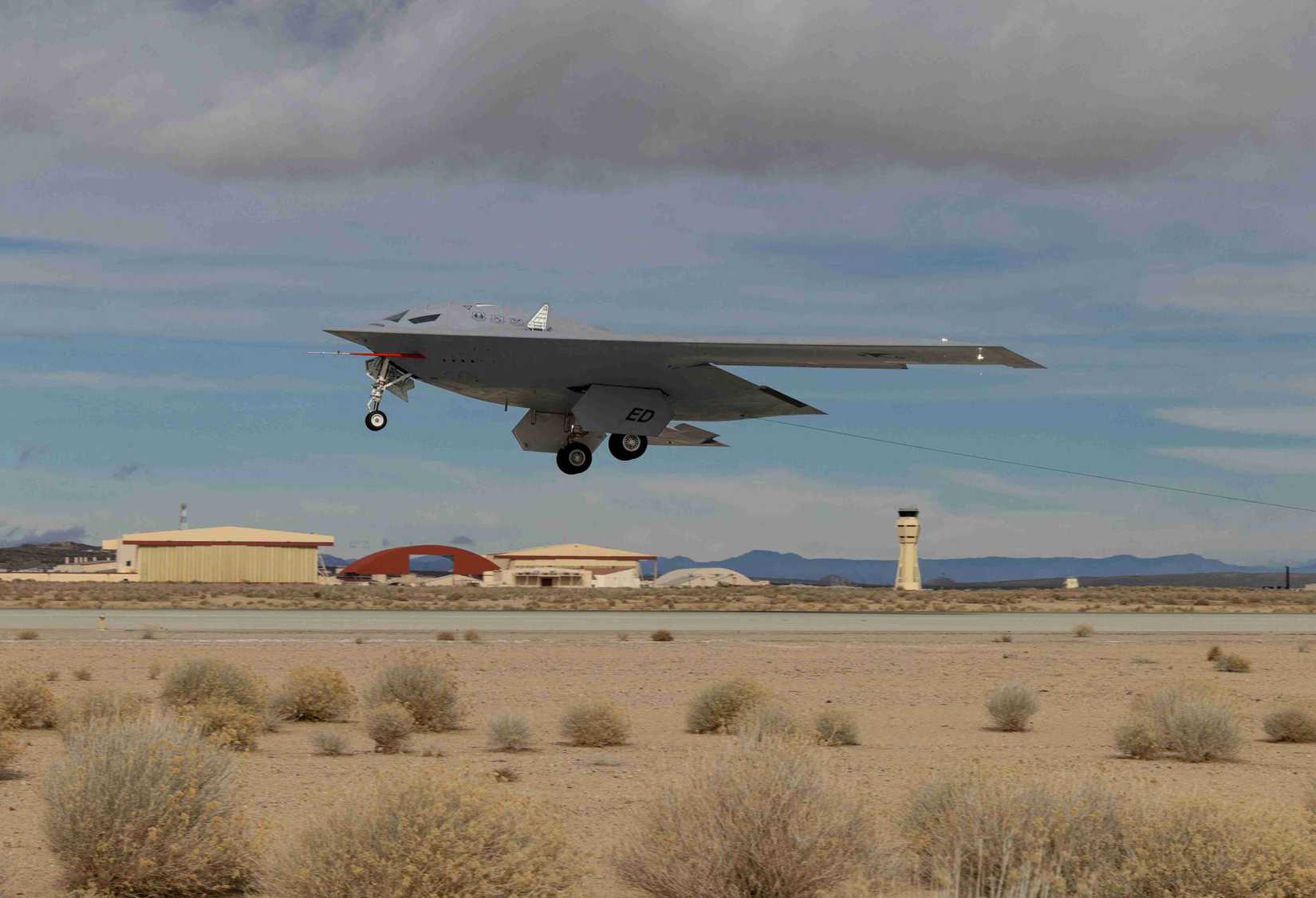 A B-21 Raider conducts flight tests, which includes ground testing, taxiing, and flying operations, at Edwards Air Force Base