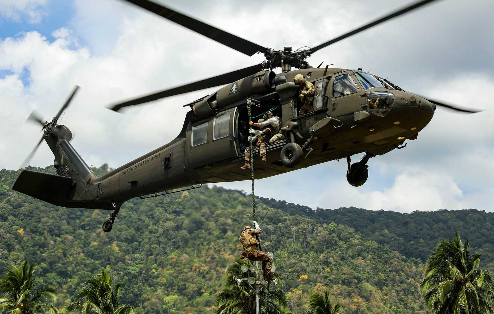 A French navy commando descends a rope from a UH-60 Blackhawk helicopter assigned to Alpha Company, 1st Battalion 169th Aviation Regiment