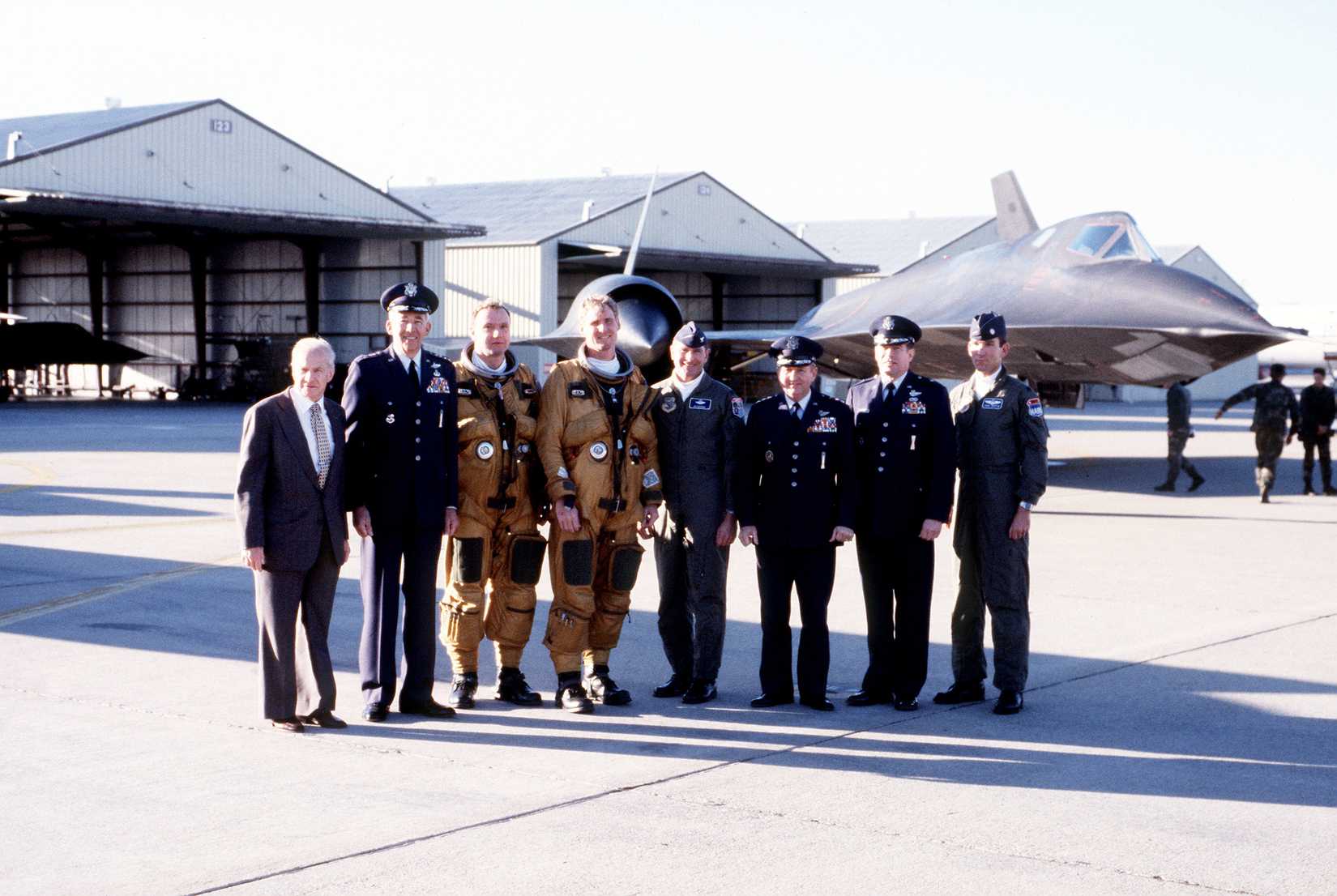 After the final operational flight of an SR-71 high-altitude reconnaissance aircraft, visiting dignitaries gather around the crew for a photograph.