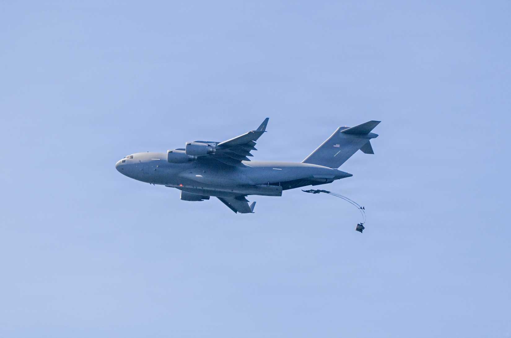 Air Force C-17 Globemaster III aircraft operated by the 446th Airlift Wing out of Joint Base Lewis-McChord drops a palletized Rigged Alternate Method Boat.