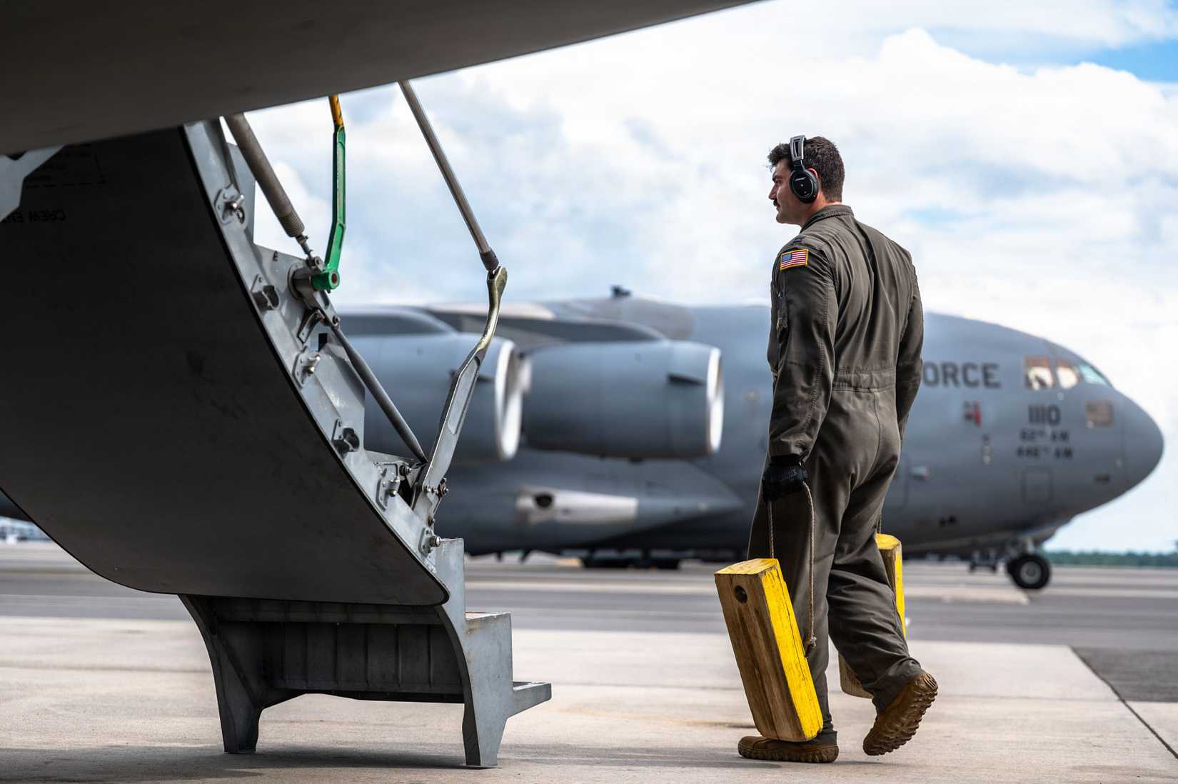 Air Force Capt. Dane Grauer, 15th Airlift Squadron C-17 Globemaster III pilot, carries aircraft chalks on board the C-17 during preflight checks.