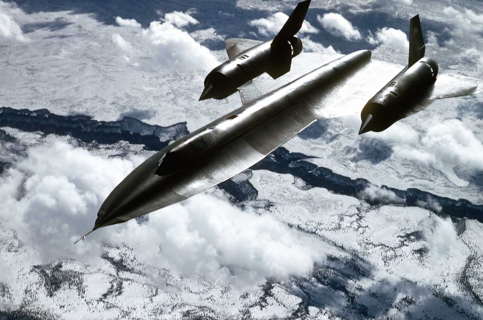Air to air, three quarter front high view, from a tanker, of a 9th Strategic Reconnaissance Wing's SR-71 Blackbird reconnaissance aircraft on a mission.