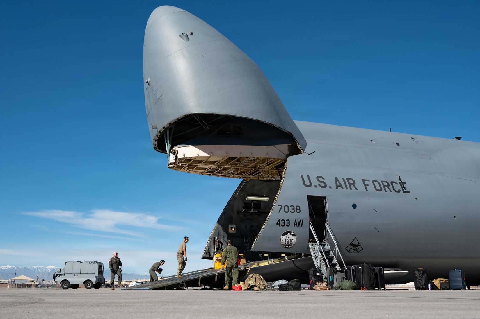 Airmen load equipment onto a C-5M Super Galaxy, assigned to the 433rd Airlift Wing, Joint Base San Antonio-Lackland, Texas.