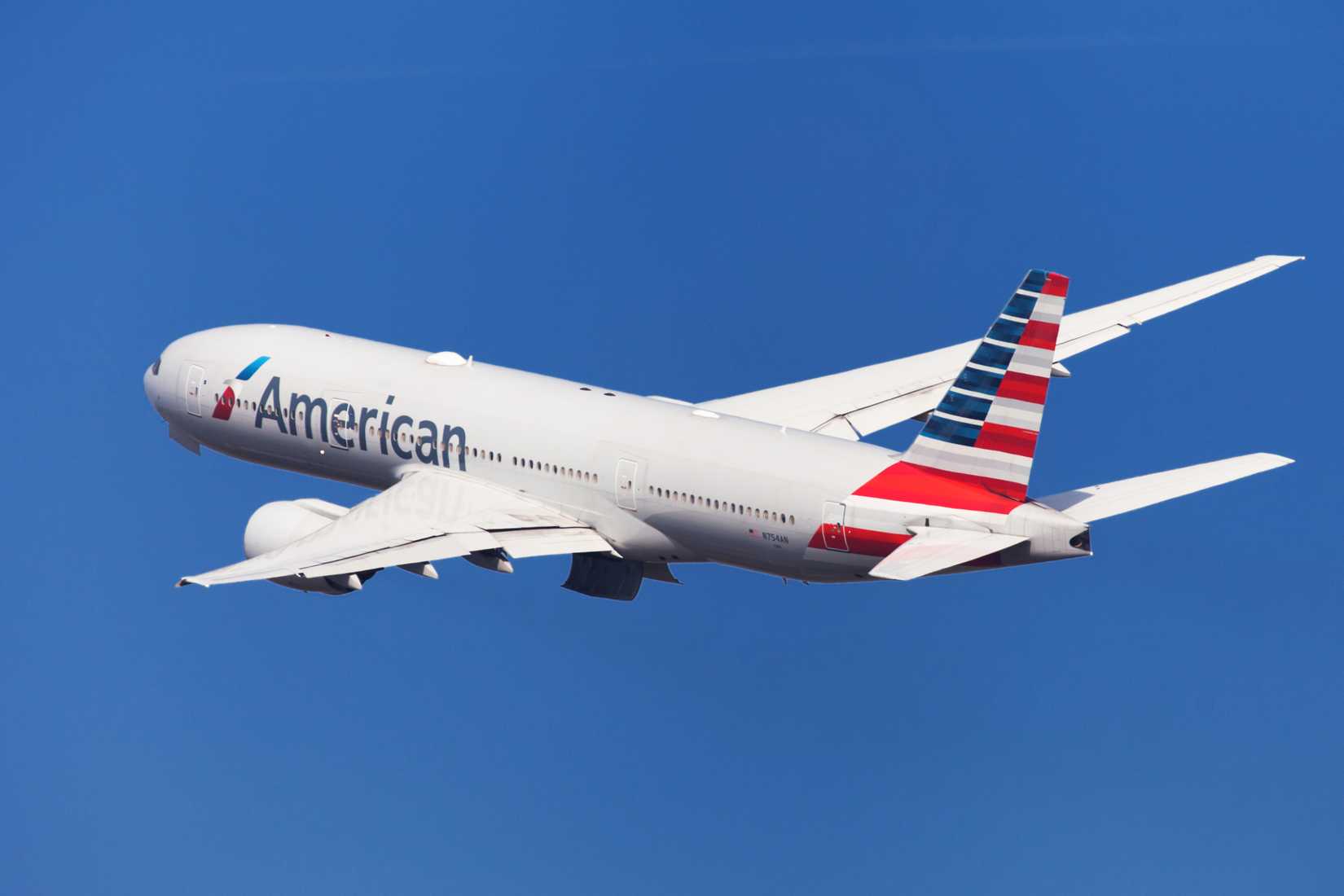 American Airlines Boeing 777-200ER banking left after taking off from El Prat Airport in Barcelona, Spain.