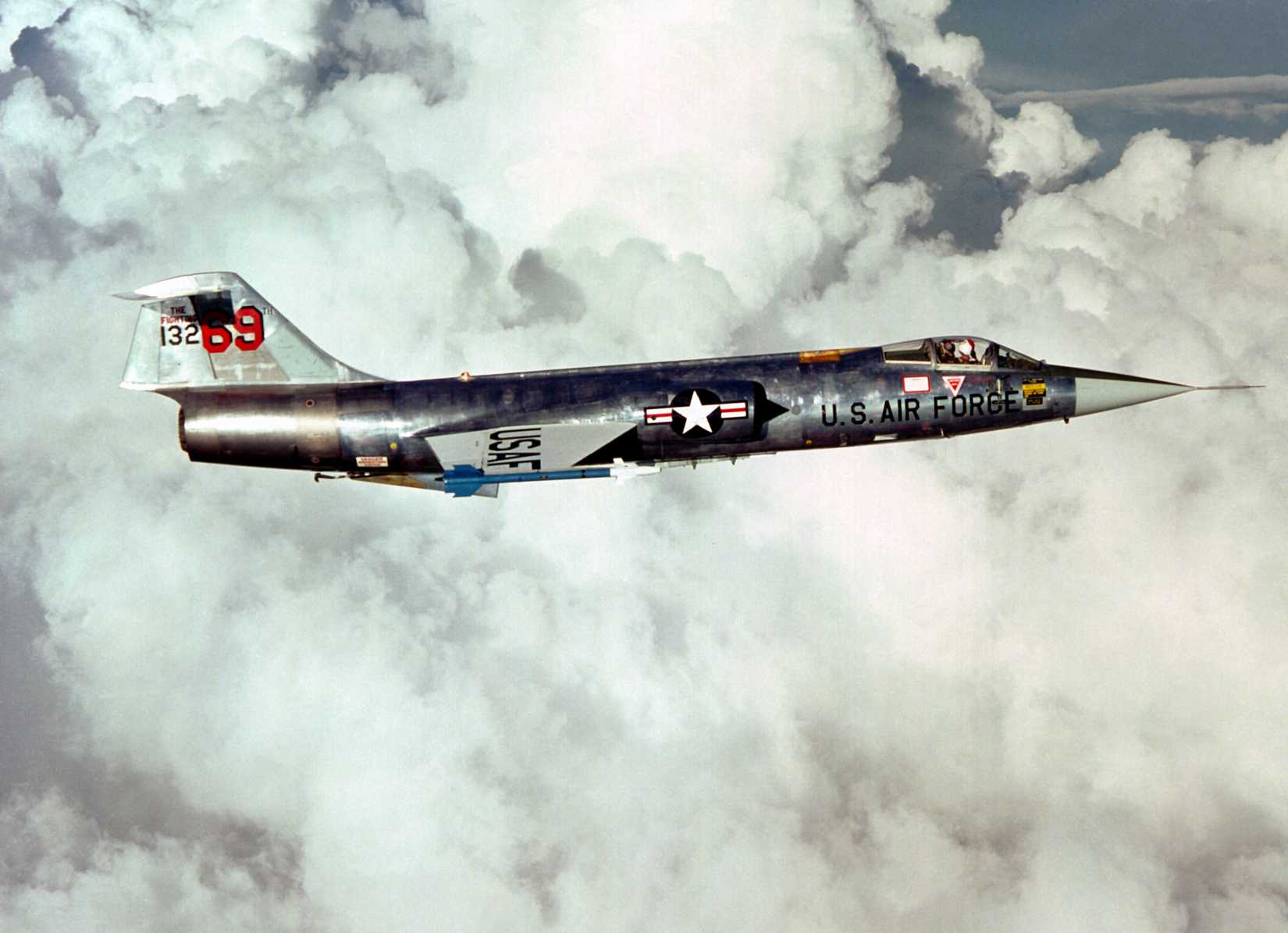 AN air-to-air right side view of an F-104 Starfighter aircraft carrying two AIM-9J Sidewinder missiles. The aircraft, from the 69th Tactical Fighter Training Squadron, 58th Tactical Training Wing, 12th Air Force.