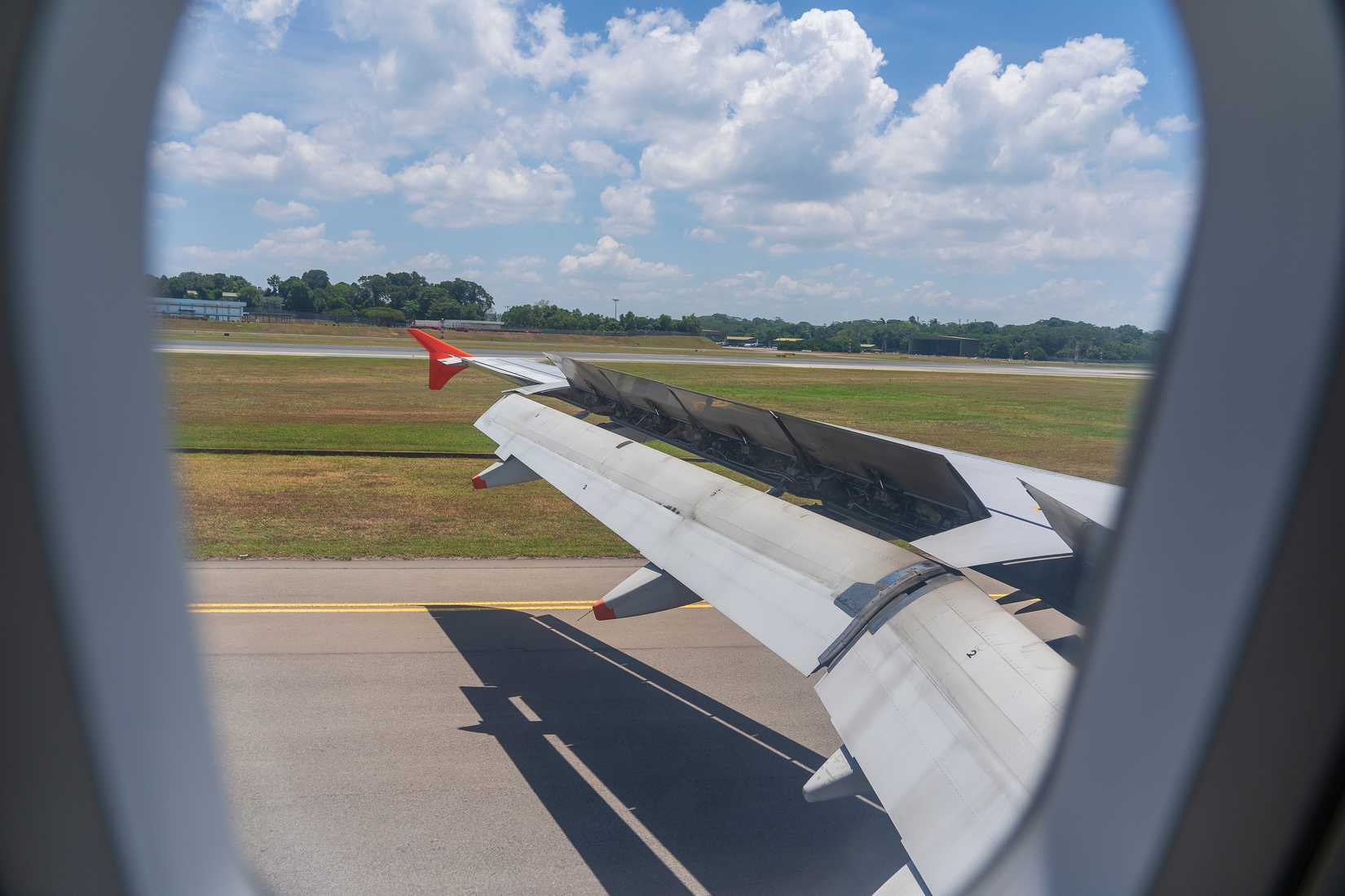 An airplane window view of wing and flaps after landing.-1