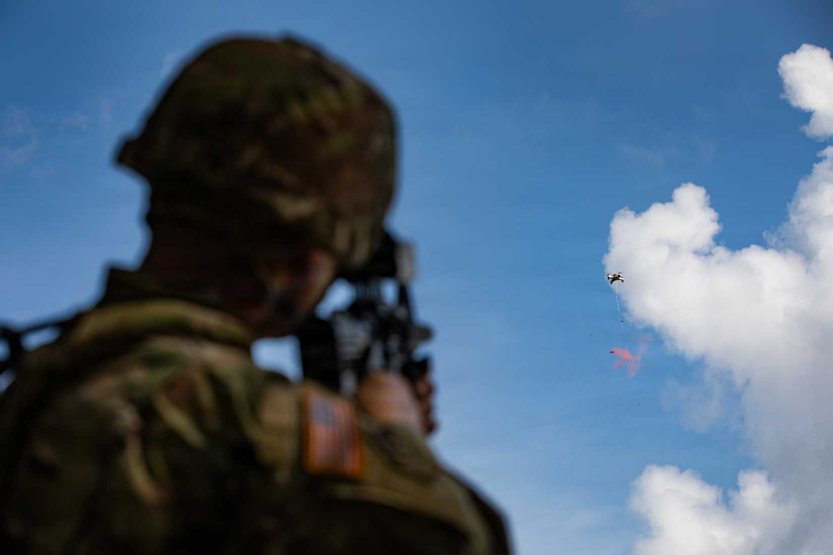 Army Reserve Staff Sgt. Dennis Degarmo, a military police assigned to the 363rd Military Police Company, shoots a balloon attached to a drone.