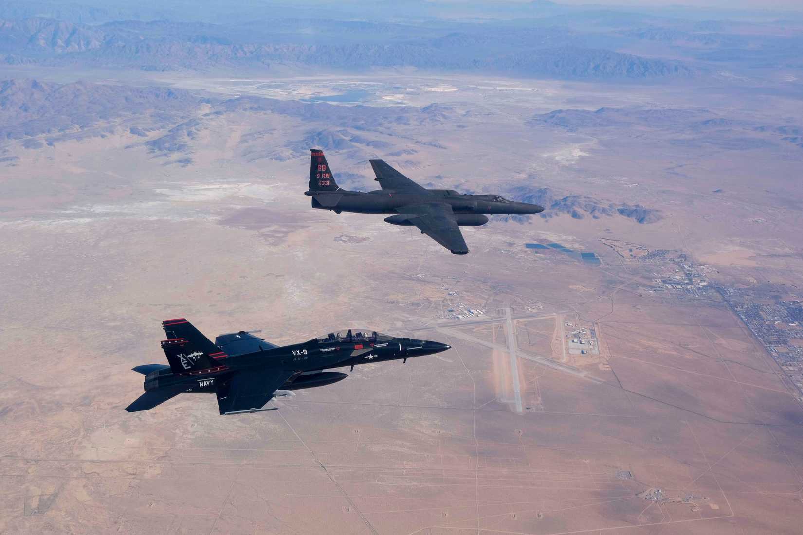  A U.S. Navy Boeing F/A-18F Lot 28 Super Hornet (BuNo 166673) of Air Test and Evaluation Squadron 9 (VX-9) "Vampires", and a U.S. Air Force Lockheed U-2S (s/n 68-10331) of the 9th Reconnaissance Wing fly over Naval Air Weapons Station China Lake, California (USA), 27 November 2023.