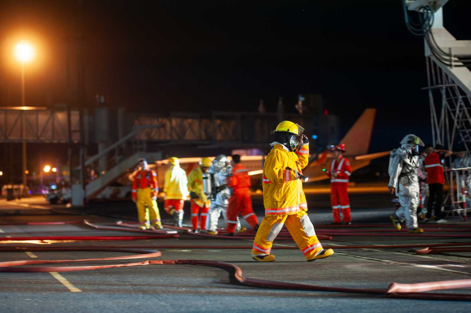 Firefighters are working in the airport at night.-1