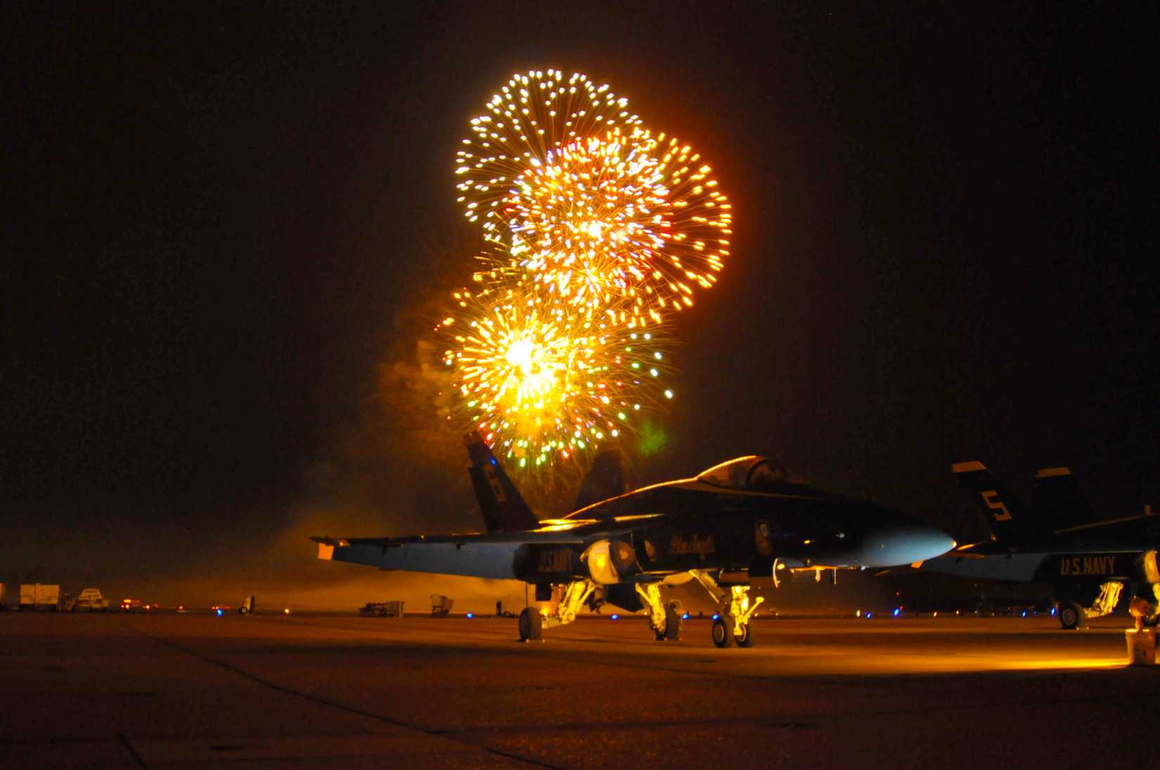 VIRGINIA BEACH, Va. (Sept. 14, 2012) An F/A-18 Hornet assigned to the U.S. Navy flight demonstration squadron, the Blue Angels, is illuminated by fireworks during the 2012 Naval Air Station Oceana Air Show. The show is currently in its 54th year, and this year celebrates the Bicentennial of the War of 1812. (U.S. Navy photo by Mass Communication Specialist 3rd Class Antonio P. Turretto Ramos/Released)
