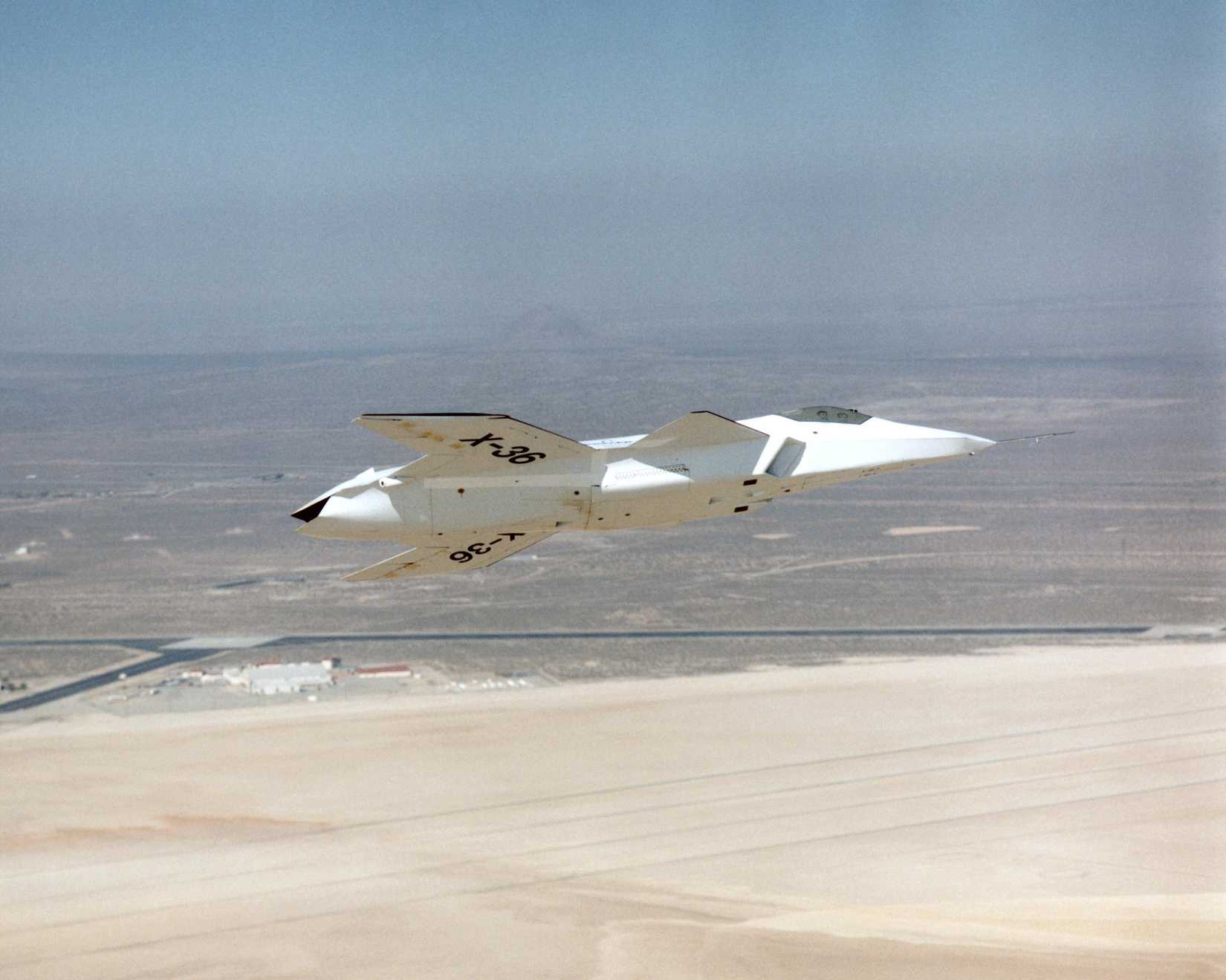 he lack of a vertical tail on the X-36 technology demonstrator is evident as the remotely piloted aircraft flies a low-altitude research flight above Rogers Dry Lake at Edwards AFB.