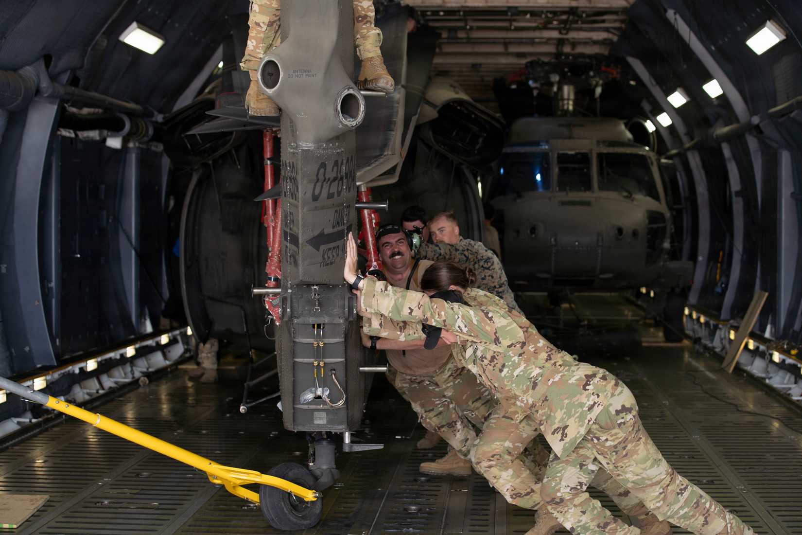 service members assigned to the 1st Battalion, 228th Aviation Regiment, Joint Task Force-Bravo, the 612th Air Base Squadron, and the 22nd Airlift Squadron onload a U.S. Army UH-60L Black Hawk.