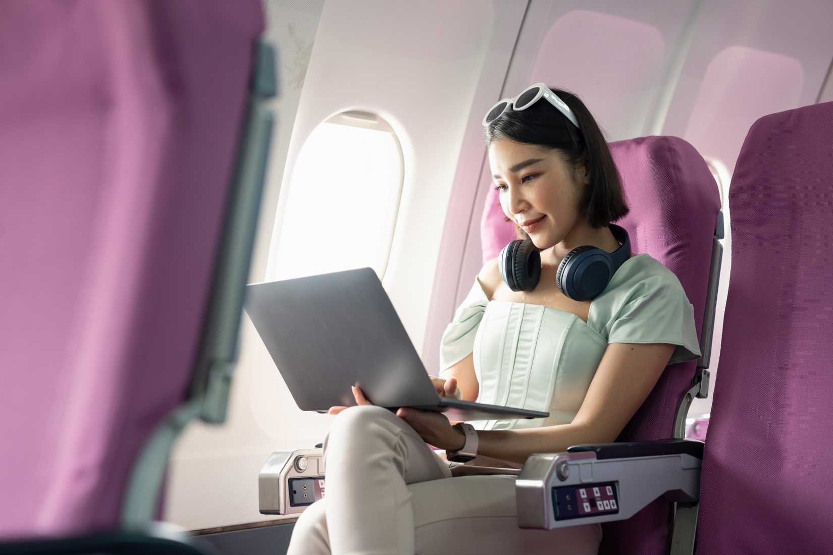 A passenger of airplane using laptop computer and wifi on board
