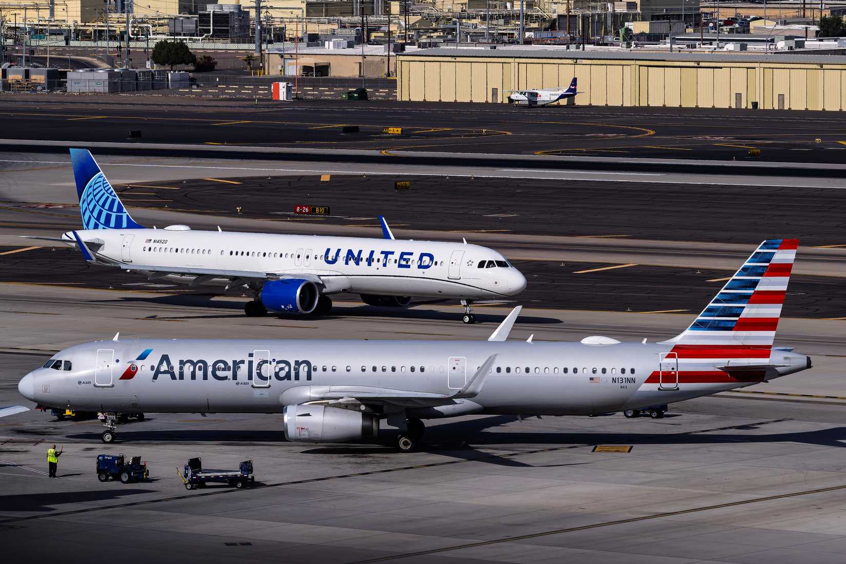 American Airlines Airbus A321neo arriving at the gate and United Airlines aircraft in the background