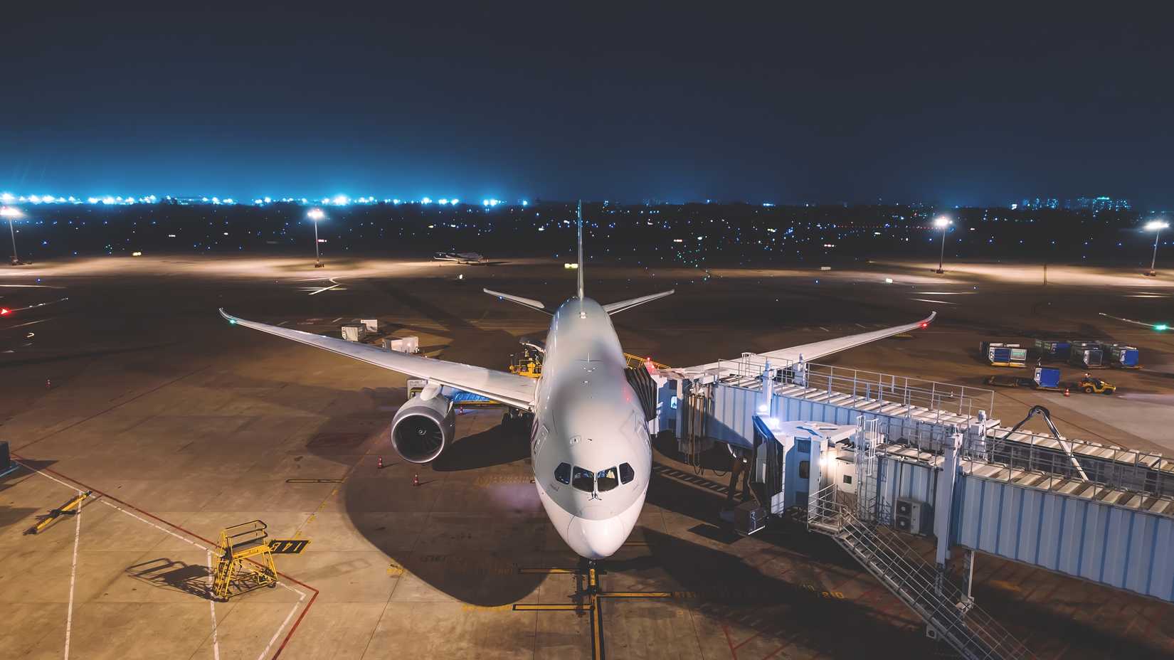 aircraft on ground attached to jetbridge at night time