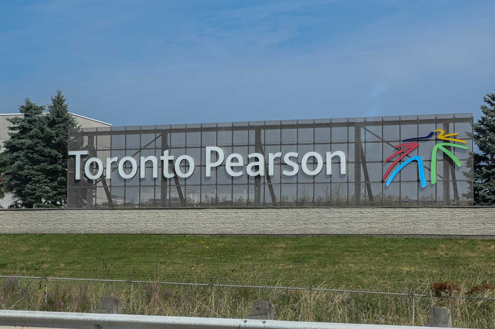 Toronto, ON, Canada - September 14, 2025: A Toronto Pearson International Airport sign stands on the side of a highway on a cloudy day.
