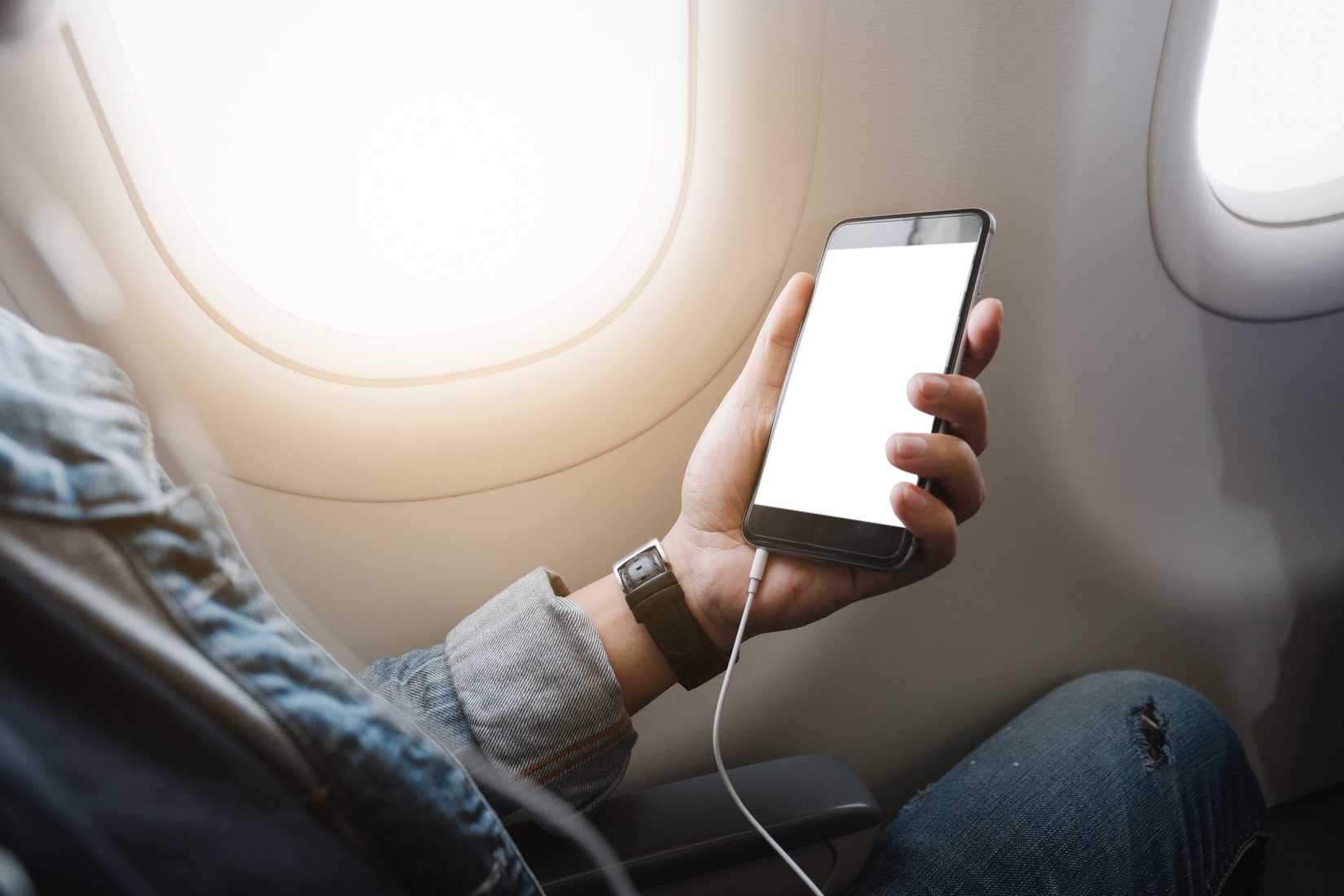 man watching entertainment on his phone in aircraft cabin