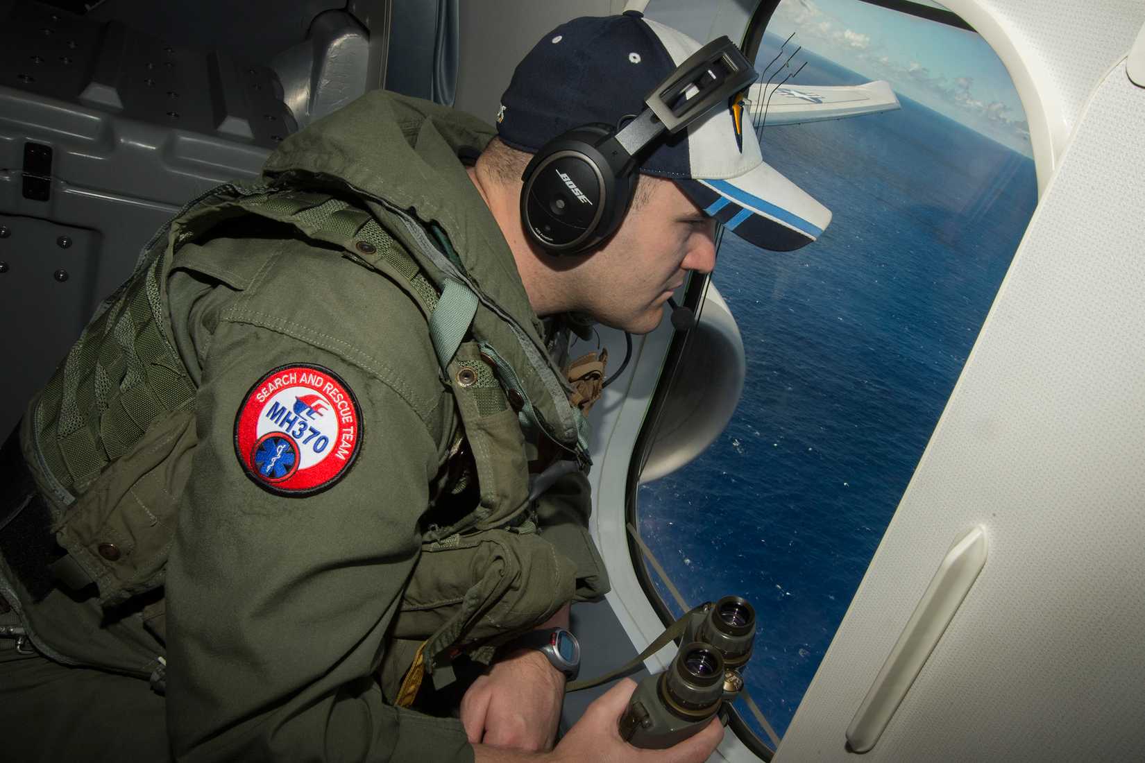 INDIAN OCEAN (April 10, 2014) Naval Aircrewman (Operator) 2nd Class Karl Shinn, assigned to Patrol Squadron (VP) 16, searches out the window of a P-8A Poseidon while flying over the Indian Ocean during a search mission to locate Malaysia Airlines flight MH370. VP-16 is deployed in the U.S. 7th Fleet area of responsibility supporting security and stability in the Indo-Asia-Pacific region. (U.S. Navy photo by Chief Mass Communication Specialist Keith DeVinney/Released)