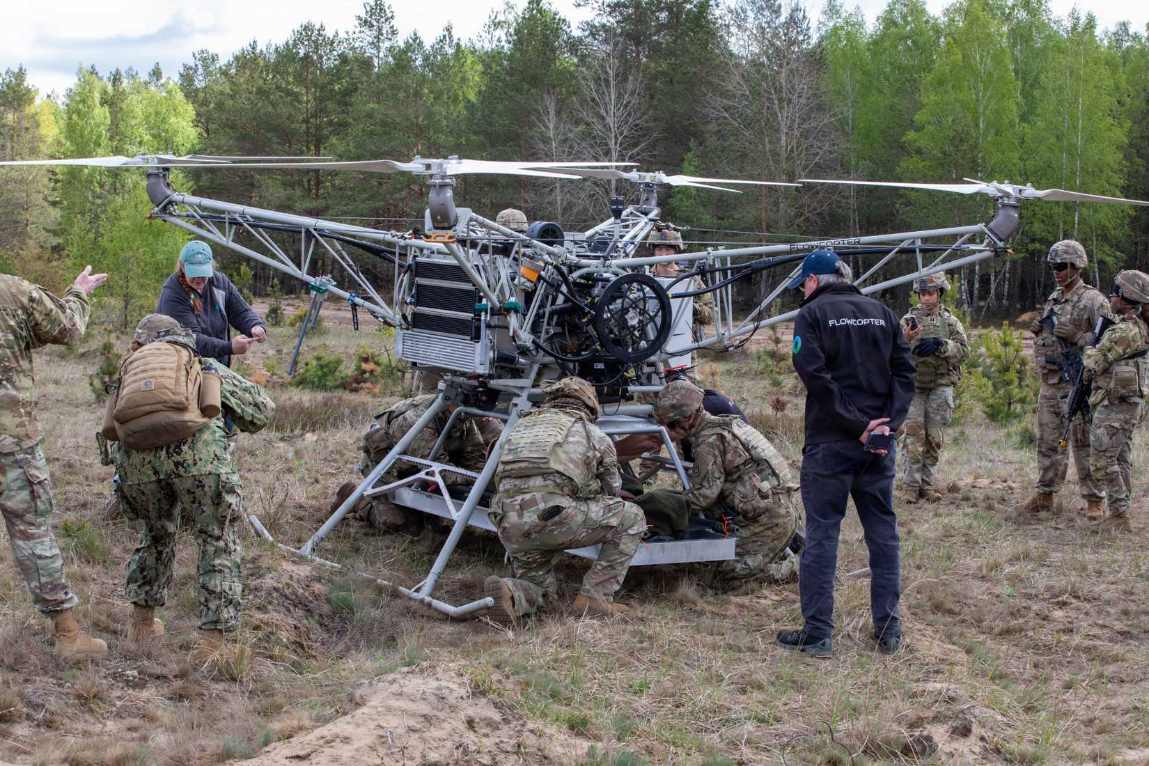 U.S. Army Soldiers assigned to the Regimental Support Squadron, 2d Cavalry Regiment, strap down a test dummy to a drone during an Autonomous Triage and Treatment Challenge.