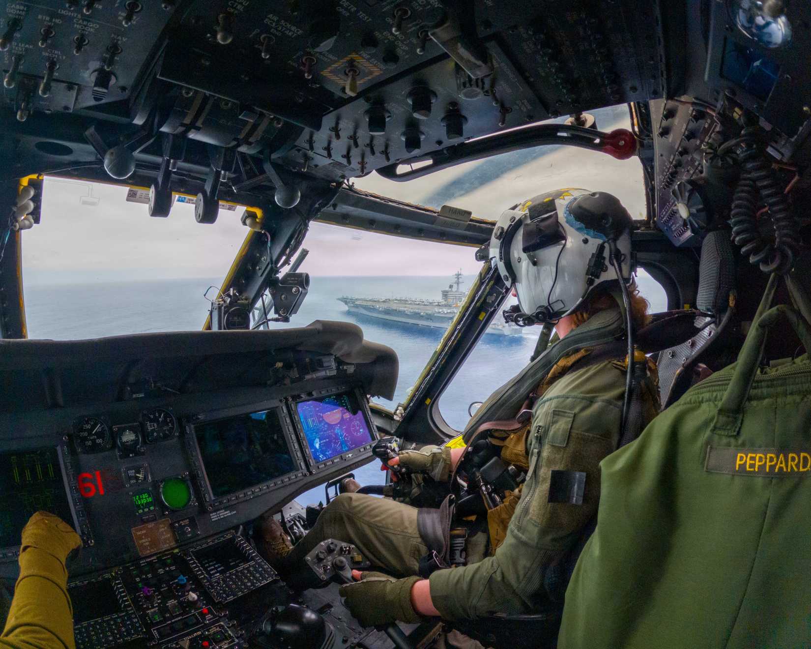 U.S. Navy Lt. Carolina Peppard flies an MH-60S Sea Hawk near the Nimitz-class aircraft carrier USS Theodore Roosevelt (CVN 71)