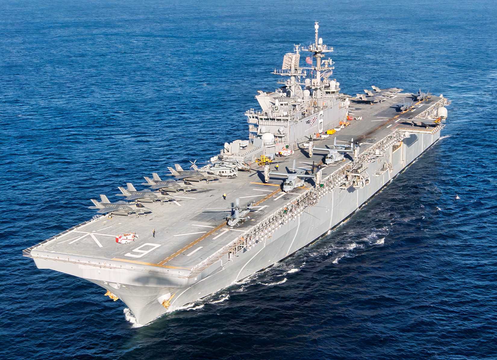 A photo of the USS America at sea with various aircraft on the flight deck.