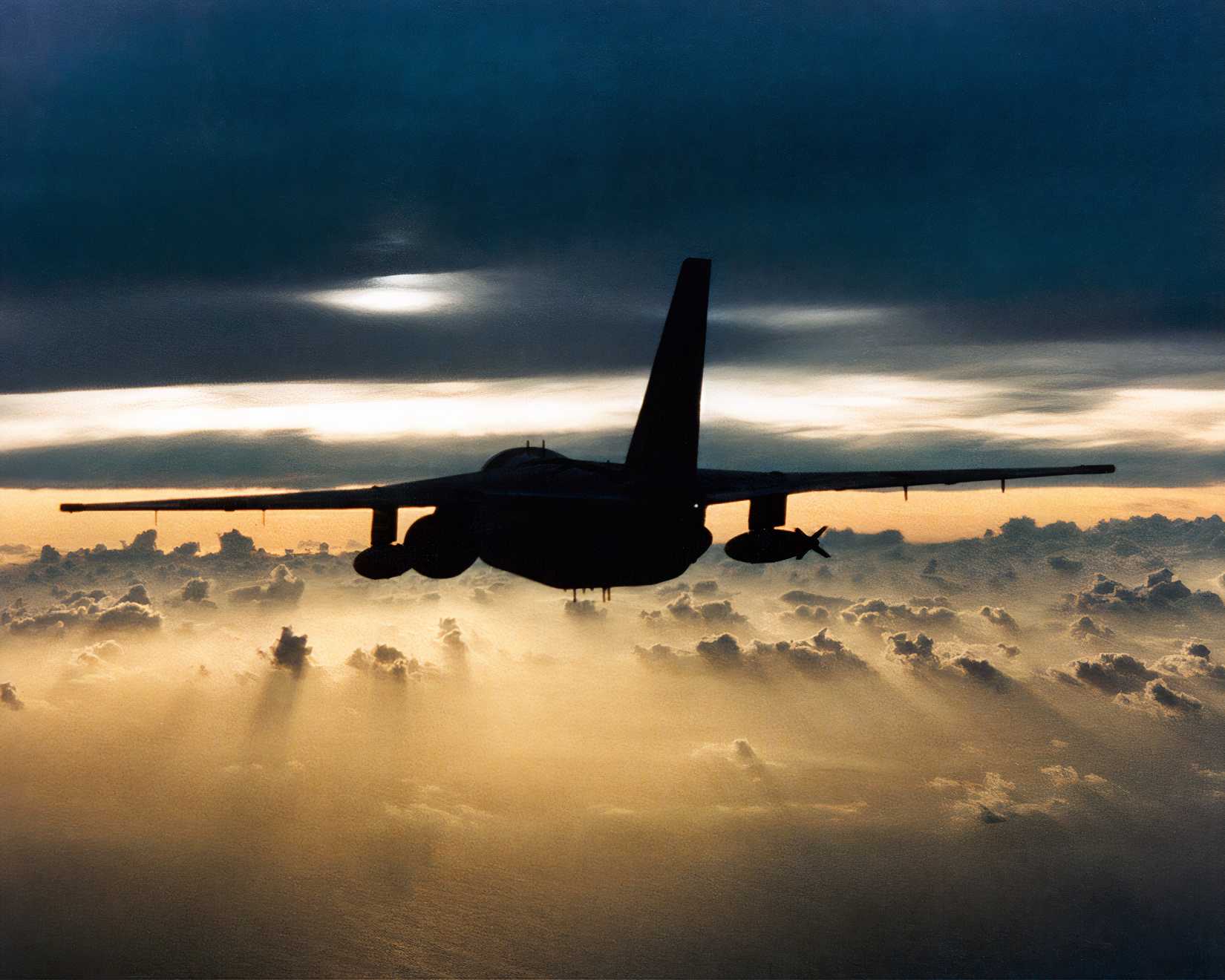 Photo of an S-3 Viking flying towards the sunst.